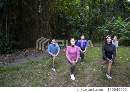 Indonesian southeast asian people in a sporty outfit practice exercise together in a public park outdoors. Concept of a Healthy active lifestyle 130049032