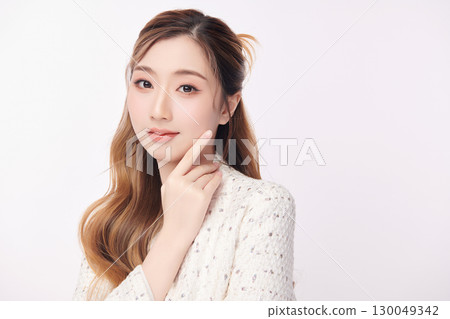 A beautiful young Asian woman with clean, fresh skin against a white background. Skincare, facial treatment, cosmetology, beauty, and spa. An elegant portrait of an Asian woman. A beautiful young Asian woman with clean, fresh skin against a white background. Skincare, facial treatment, cosmetology, beauty, and spa. An elegant portrait of an Asian woman. 130049342
