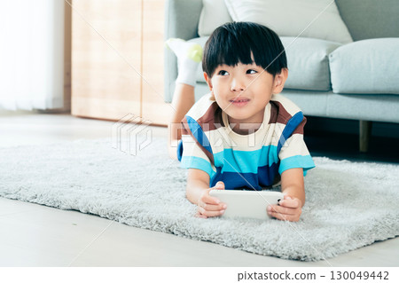 Boy playing with a smartphone Boy playing with a smartphone 130049442