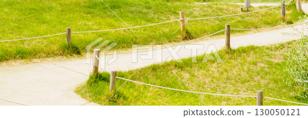 Scenery of a promenade surrounded by green grass Scenery of a promenade surrounded by green grass 130050121
