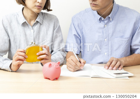 A couple discussing household finances on a white background A couple discussing household finances on a white background 130050204