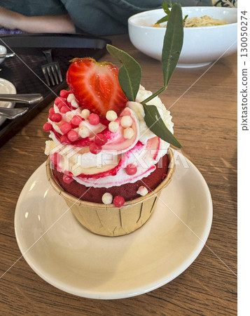 Delicious strawberry cupcakes finished with fluffy whipped cream and garnished with fresh strawberries, creating a harmonious balance of flavor and elegance perfect for summer celebrations. Delicious strawberry cupcakes finished with fluffy whipped cream and garnished with fresh strawberries, creating a harmonious balance of flavor and elegance perfect for summer celebrations. 130050274