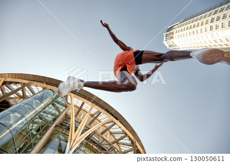 Athlete Jumps Over a Building Background Capturing Energy and Motion Athlete Jumps Over a Building Background Capturing Energy and Motion 130050611