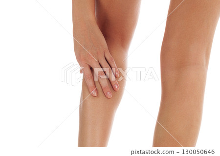 Woman touches her painful shin, isolated on white background 130050646