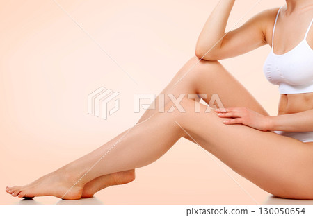 Pretty woman with slim beautiful body sitting against pastel background 130050654