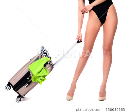 young woman in a black swimsuit standing with a suitcase, isolated on a white background, summer vacations concept young woman in a black swimsuit standing with a suitcase, isolated on a white background, summer vacations concept 130050663