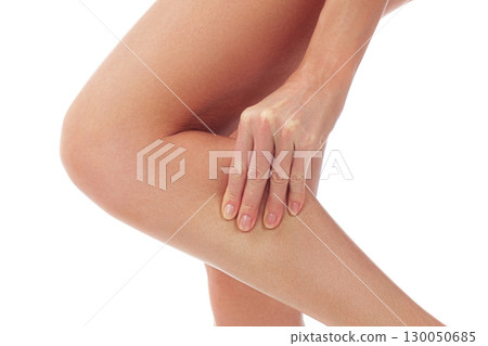 Woman touches her painful shin, isolated on white background 130050685
