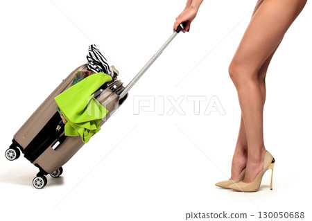 Closeup shot of woman who is pulling a suitcase, isolated on a white background, summer vacations concept Closeup shot of woman who is pulling a suitcase, isolated on a white background, summer vacations concept 130050688