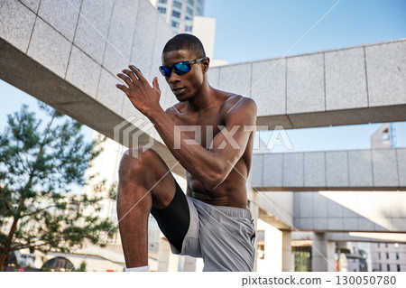 Athletic man exercising outdoors in an urban environment under a clear sky 130050780