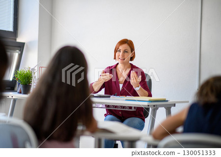 Teacher talking with children in primary class. Teacher talking with children in primary class. 130051333