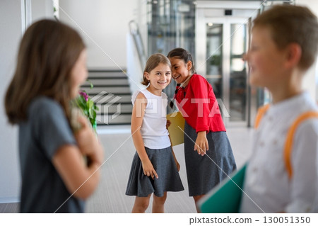 Schoolgirls teasing or gossiping about classmates. 130051350