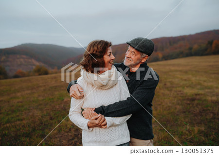 Senior couple embracing in autumn sunset light. 130051375