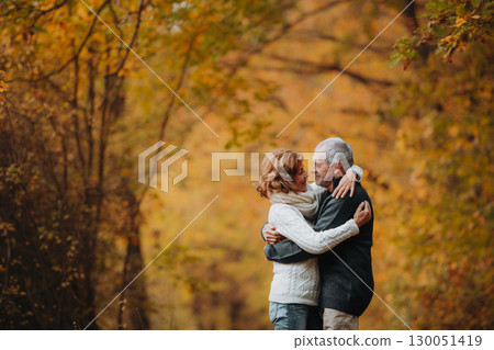 Older couple spending time outdoors in fall season. 130051419