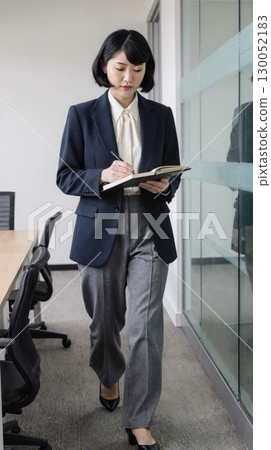 Smiling businesswoman holding a tablet 130052183