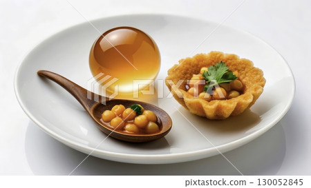 Unique dessert presentation with caviar-like spheres and pastry on a white plate 130052845