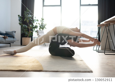 Partner yoga indoors, two women in stretching balance training with focus and harmony. 130052911