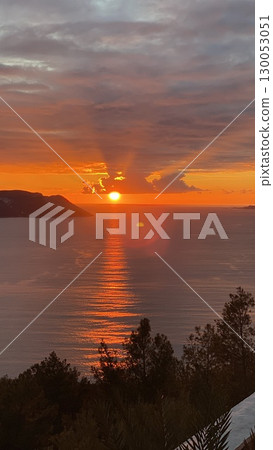 Sunset over calm ocean with vibrant sky reflecting on water, creating serene landscape background Sunset over calm ocean with vibrant sky reflecting on water, creating serene landscape background 130053051