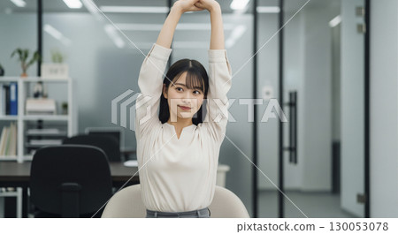 Businesswoman stretching with her arms folded above her head 130053078