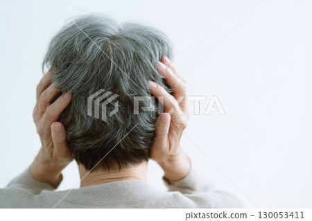 Elderly woman holding her head 130053411