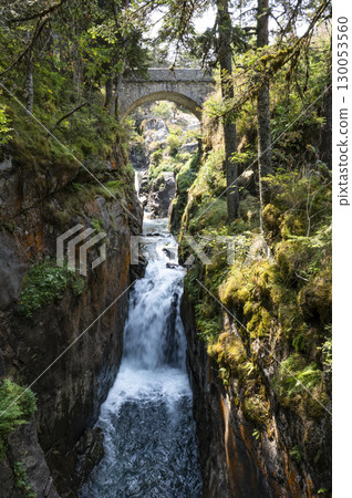 Flowing water cascades through rocky terrain in the Pyrenees near Cauteret, highlighting the beauty Flowing water cascades through rocky terrain in the Pyrenees near Cauteret, highlighting the beauty 130053560