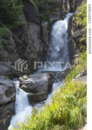 Flowing water cascades through rocky terrain in the Pyrenees near Cauteret, highlighting the beauty 130053664