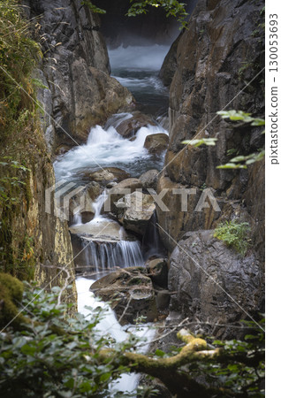 Flowing water cascades through rocky terrain in the Pyrenees near Cauteret, highlighting the beauty Flowing water cascades through rocky terrain in the Pyrenees near Cauteret, highlighting the beauty 130053693