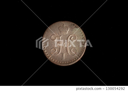 A rare Tsar Nicholas I coin from Russia, its detailed N initial clearly visible, against a stark black background. This historical piece of money speaks to the imperial era. A rare Tsar Nicholas I coin from Russia, its detailed N initial clearly visible, against a stark black background. This historical piece of money speaks to the imperial era. 130054292