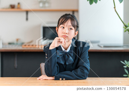 Junior high school, high school, and elementary school students in uniforms with troubled expressions, worried at home 130054578