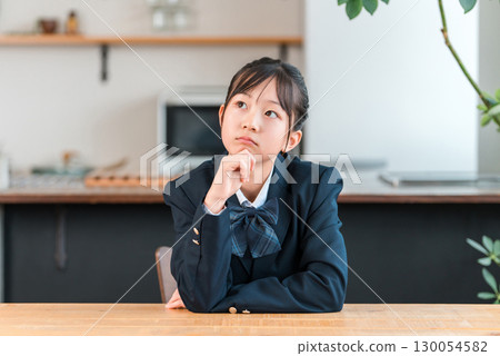 Junior high school, high school, and elementary school students in uniforms with troubled expressions, worried at home 130054582