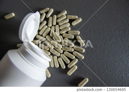 Much medical green pills and drugs in transparent package in white bottle. Healthcare concept. BAA or biologically active additives. Much medical green pills and drugs in transparent package in white bottle. Healthcare concept. BAA or biologically active additives. 130054695