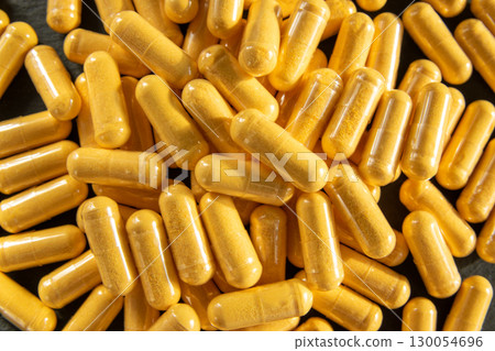 Much medical yellow pills and drugs in transparent package on the black stone. Healthcare concept. BAA or biologically active additives. Much medical yellow pills and drugs in transparent package on the black stone. Healthcare concept. BAA or biologically active additives. 130054696