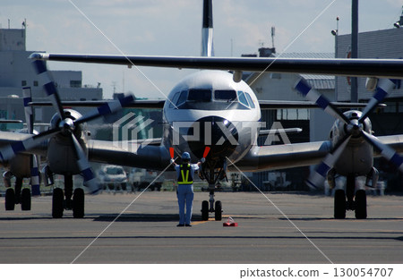 地勤人員發出螺旋槳飛機抵達的訊號 地勤人員發出螺旋槳飛機抵達的訊號 130054707
