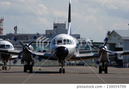 Front view of a propeller plane departing from an airport in summer Front view of a propeller plane departing from an airport in summer 130054709