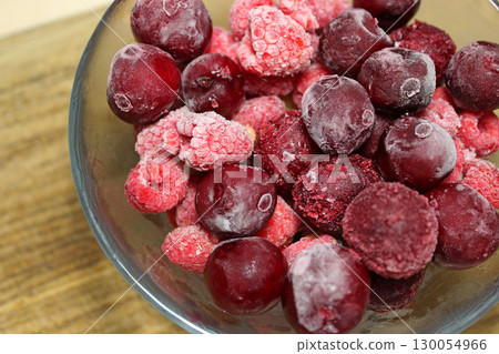 Closeup View Of Frozen Mixed Fruit Berries In A Glass On Wood Plank Stock Photo 130054966