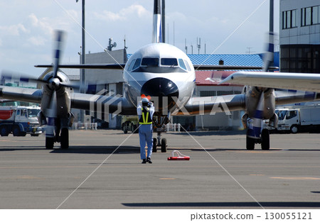 地勤人員發出螺旋槳飛機抵達的訊號 地勤人員發出螺旋槳飛機抵達的訊號 130055121