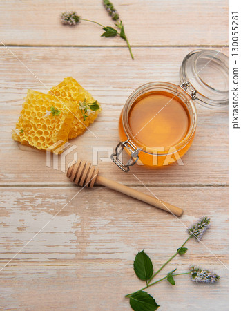 Honeycomb, jar of honey and wooden honey dipper on rustic table Honeycomb, jar of honey and wooden honey dipper on rustic table 130055281