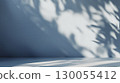 Soft sunlight and shadows on blue wall interior with clean minimal design, copy space 130055412