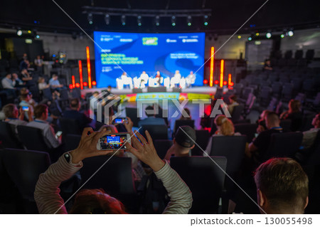 Audience photographing presentation during a live business panel in a conference room 130055498
