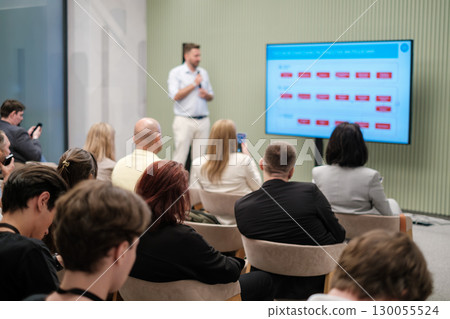 Speaker presenting in business seminar with attentive audience and display screen Speaker presenting in business seminar with attentive audience and display screen 130055524