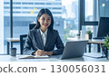 一位微笑的女商人在漂亮的辦公室裡用筆記型電腦工作 130056031