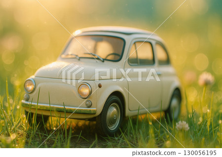 Miniature Vintage Car In Sunlit Meadow With Dewy Grass 130056195