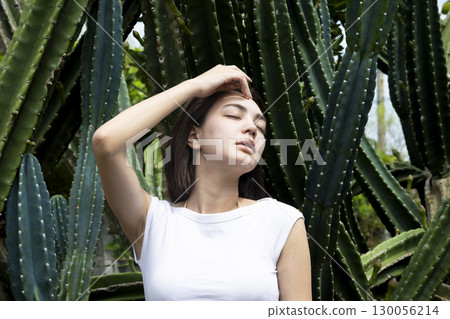 Beautiful woman standing in front of a cactus 130056214
