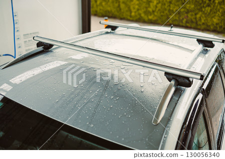 The stylish and sleek silver cars roof elegantly showcases mesmerizing rain drops, complemented by a strong roof railing designed for outdoor adventures and the secure transport of sports equipment 130056340