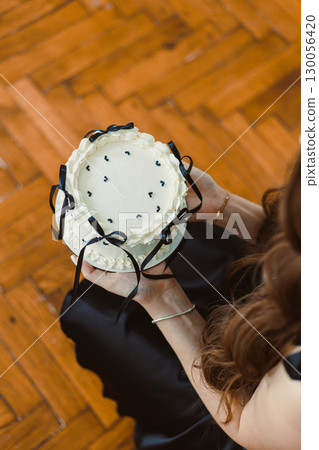 This elegant cake with luxurious black ribbons is a perfect centerpiece for celebrations, enhancing romantic anniversaries and lively birthday parties with class and delightful flavor 130056420