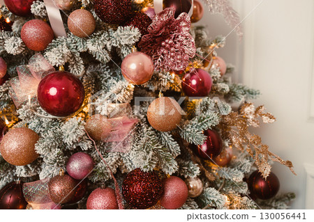 An Elegant Christmas Tree, beautifully decorated with captivating glittering ornaments, shining in lovely shades of vibrant red and pink, creating a delightful atmosphere for the holiday season 130056441