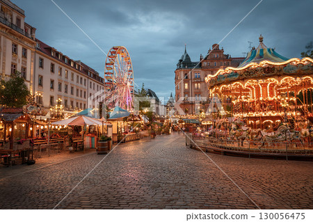Oktoberfest sparkles at night with bright lights, rides and a festive atmosphere. Carousels and a fair on the square in Bavaria. 130056475