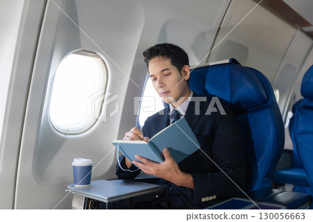 Airplane, travel and portrait of businessman working on laptop computer and smartphone while sitting in airplane. Airplane, travel and portrait of businessman working on laptop computer and smartphone while sitting in airplane. 130056663