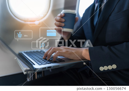 Traveling and technology. young business man working on Laptop and smartphone while sitting in airplane. Traveling and technology. young business man working on Laptop and smartphone while sitting in airplane. 130056674