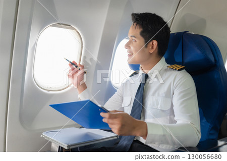Portrait of a trained airplane captain in uniform preparing to fly in a simulator cockpit. 130056680