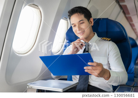 Portrait of a trained airplane captain in uniform preparing to fly in a simulator cockpit. 130056681